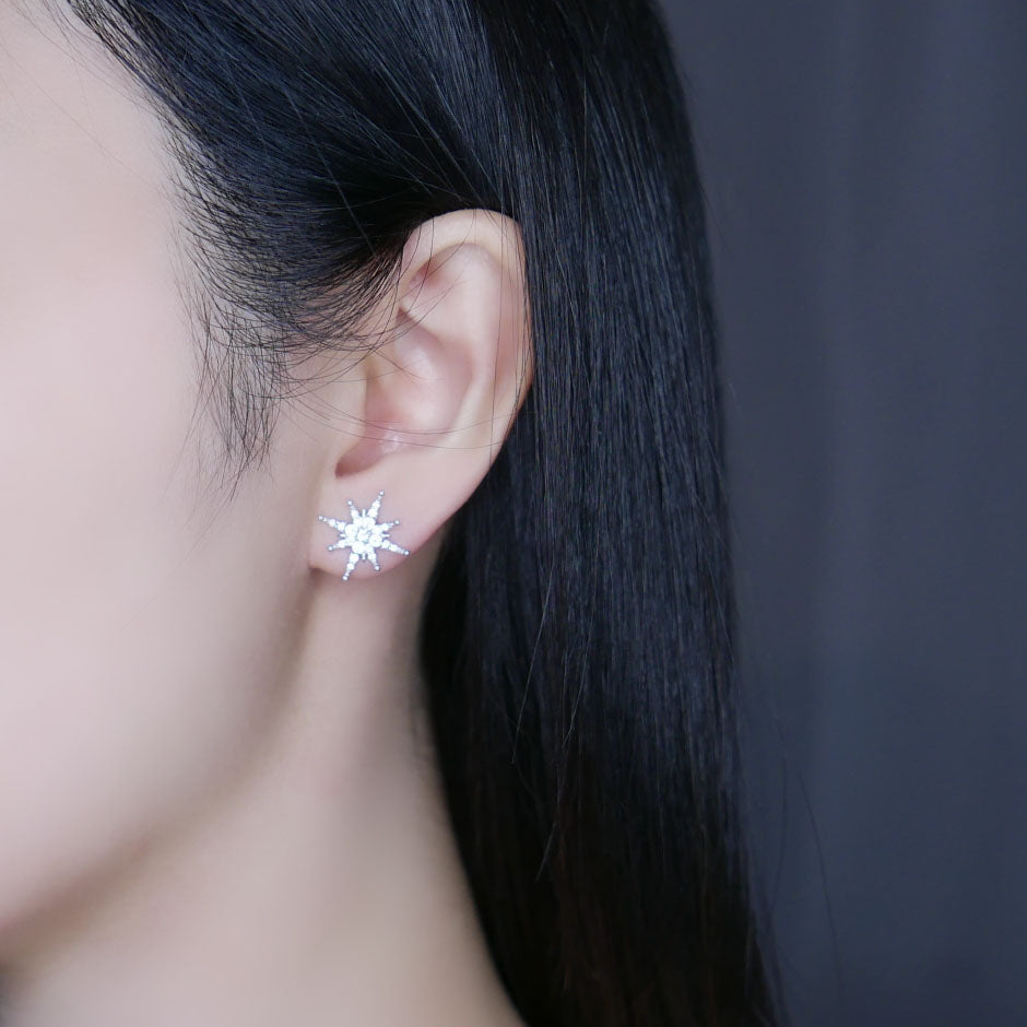 Model wearing silver Becca star drop earrings
