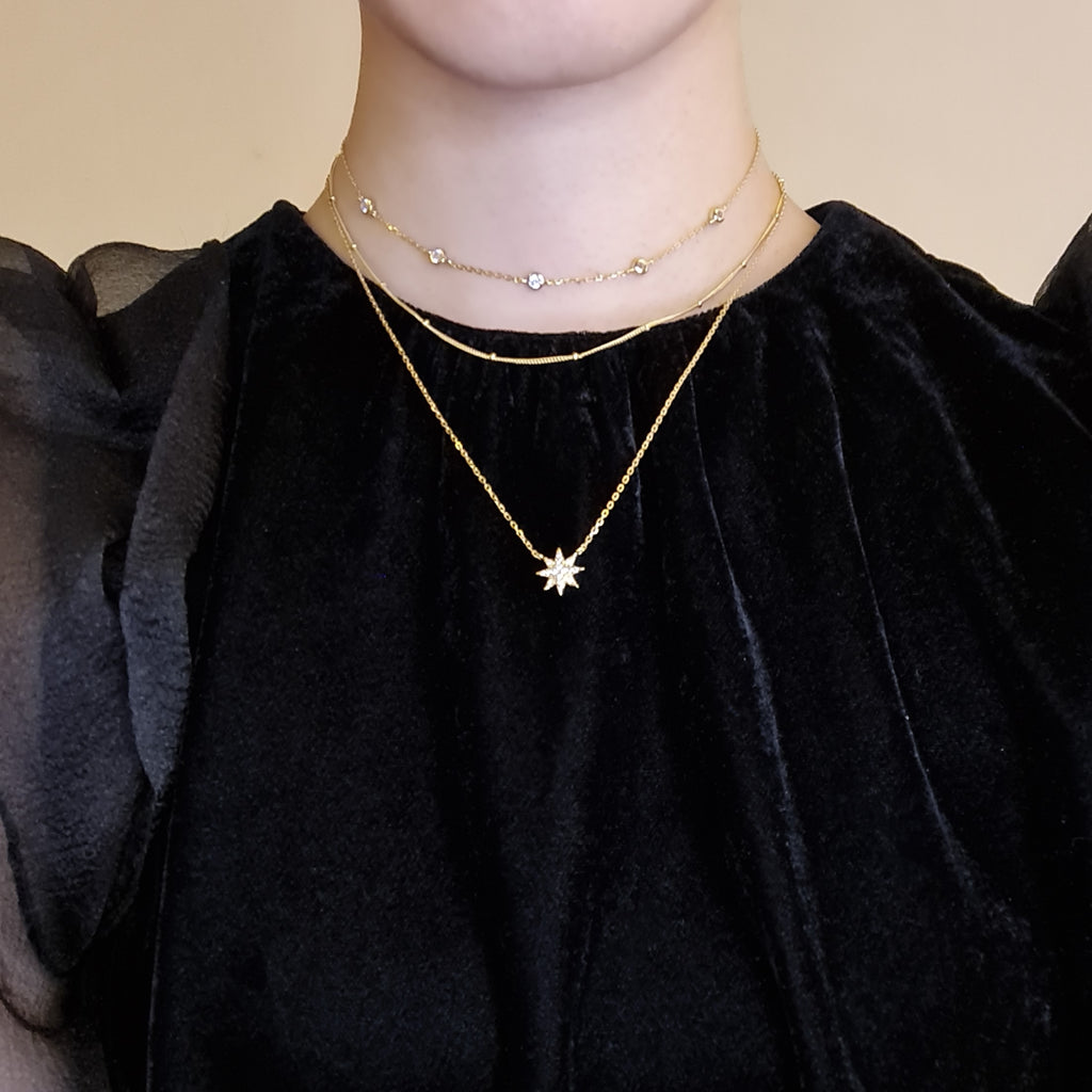 Model wearing Celeste Gold star necklace with 2 layered choker style necklaces 