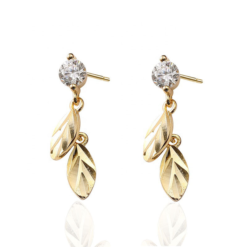 Gold leaf drop earrings on white background