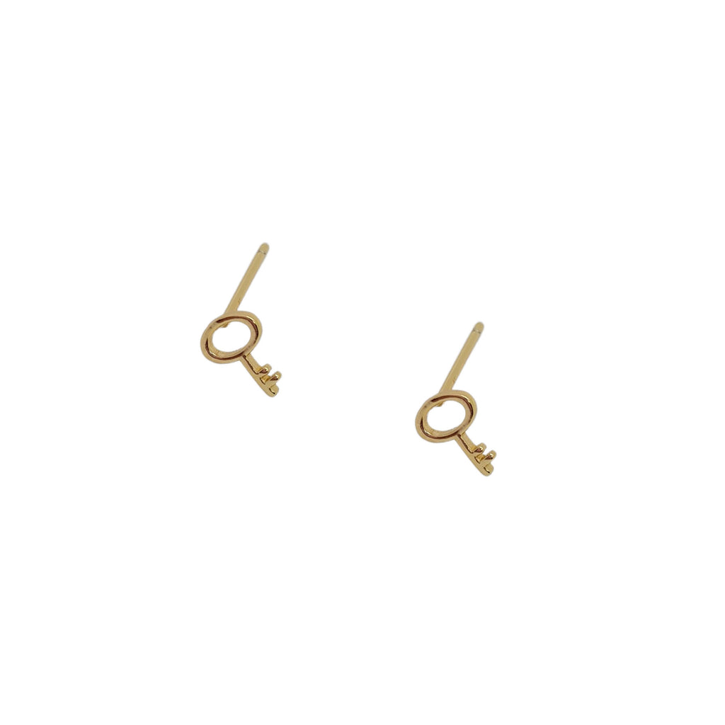 Gold key stud earrings on white background