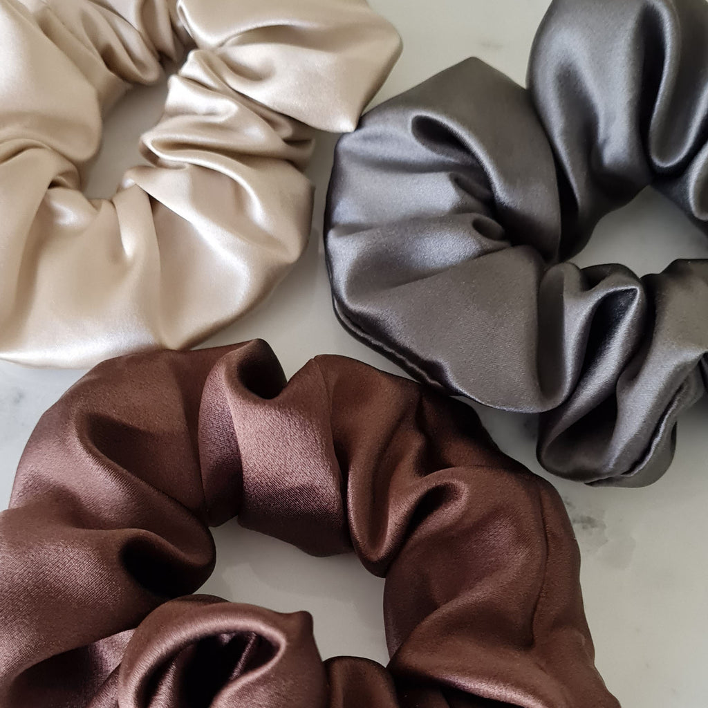 Brown, grey, champagne silk scrunchies on marble table