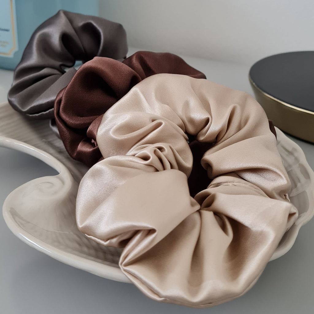 Neutrals Luxe Silk Scrunchies on a shell tray