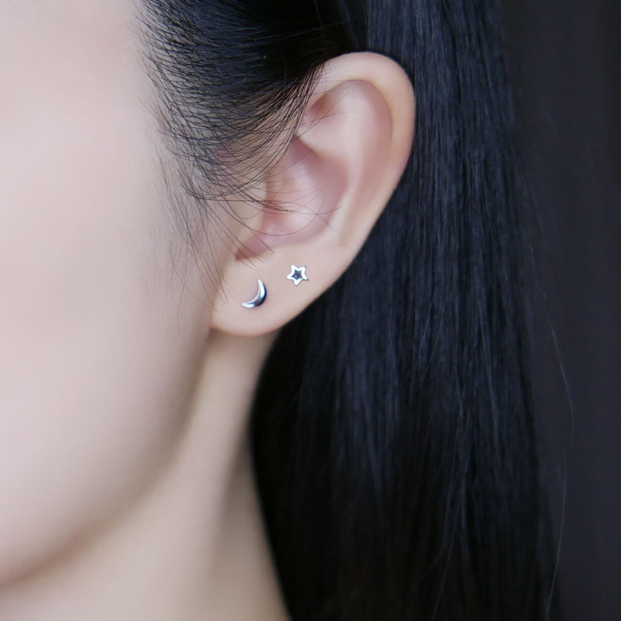 Model wearing silver moon star stud earrings