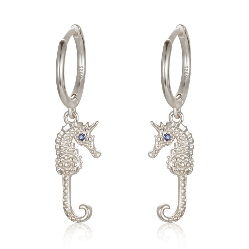 Silver seahorse huggie hoop earrings. Blue gem on seahorse's eye