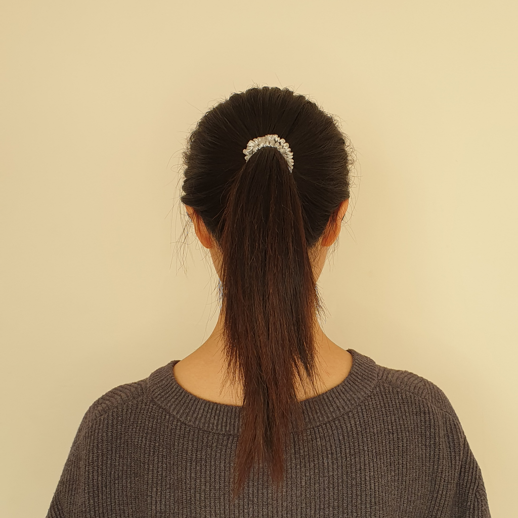 Silver slim silk scrunchie in model's hair